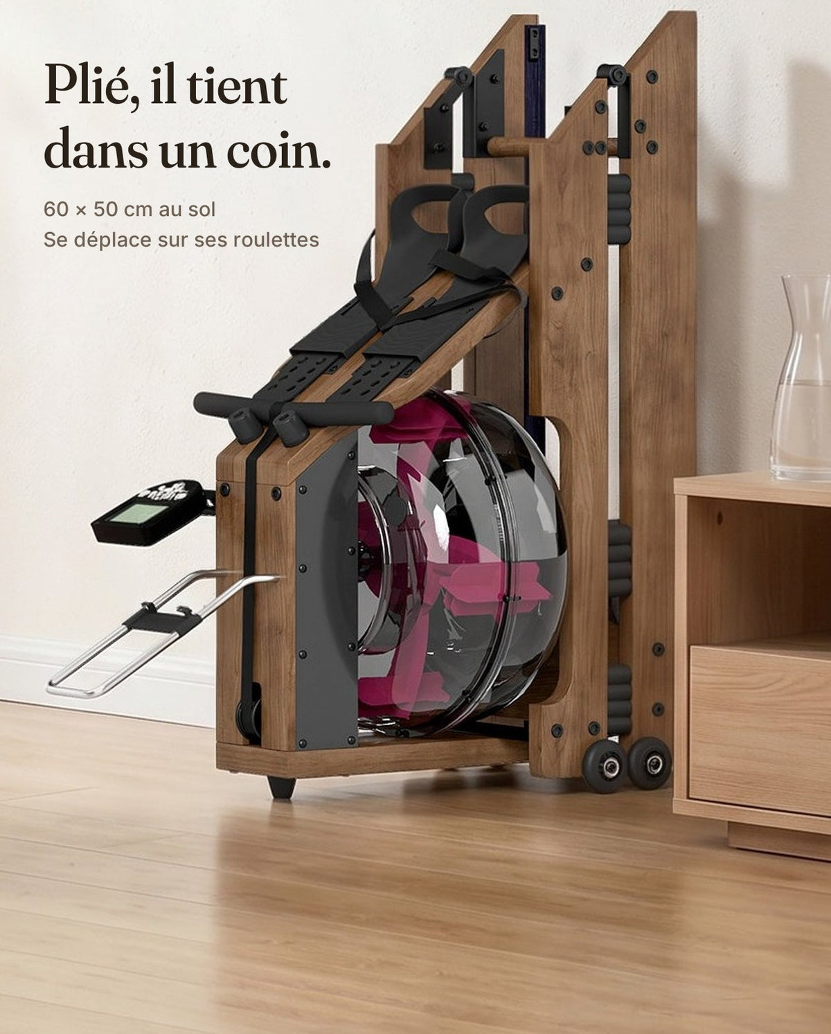 Rameur à eau en bois plié debout dans un salon : 60 × 50 cm au sol, déplacé sur ses roulettes